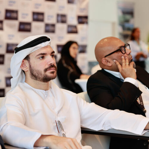 arabic Man in traditional suit sitting at a business event