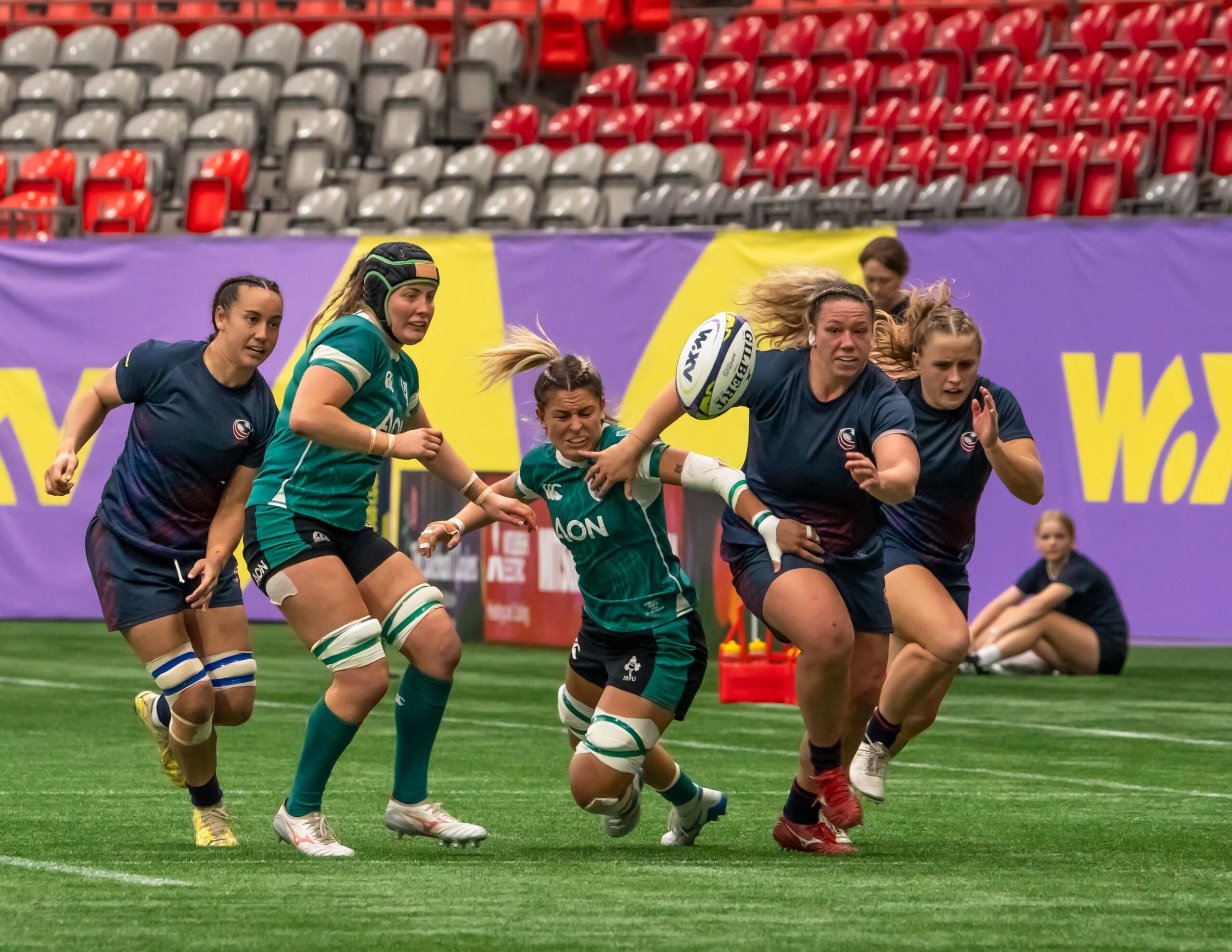 Canada Women's Rugby player in white kit attempting to evade an Ireland defender.