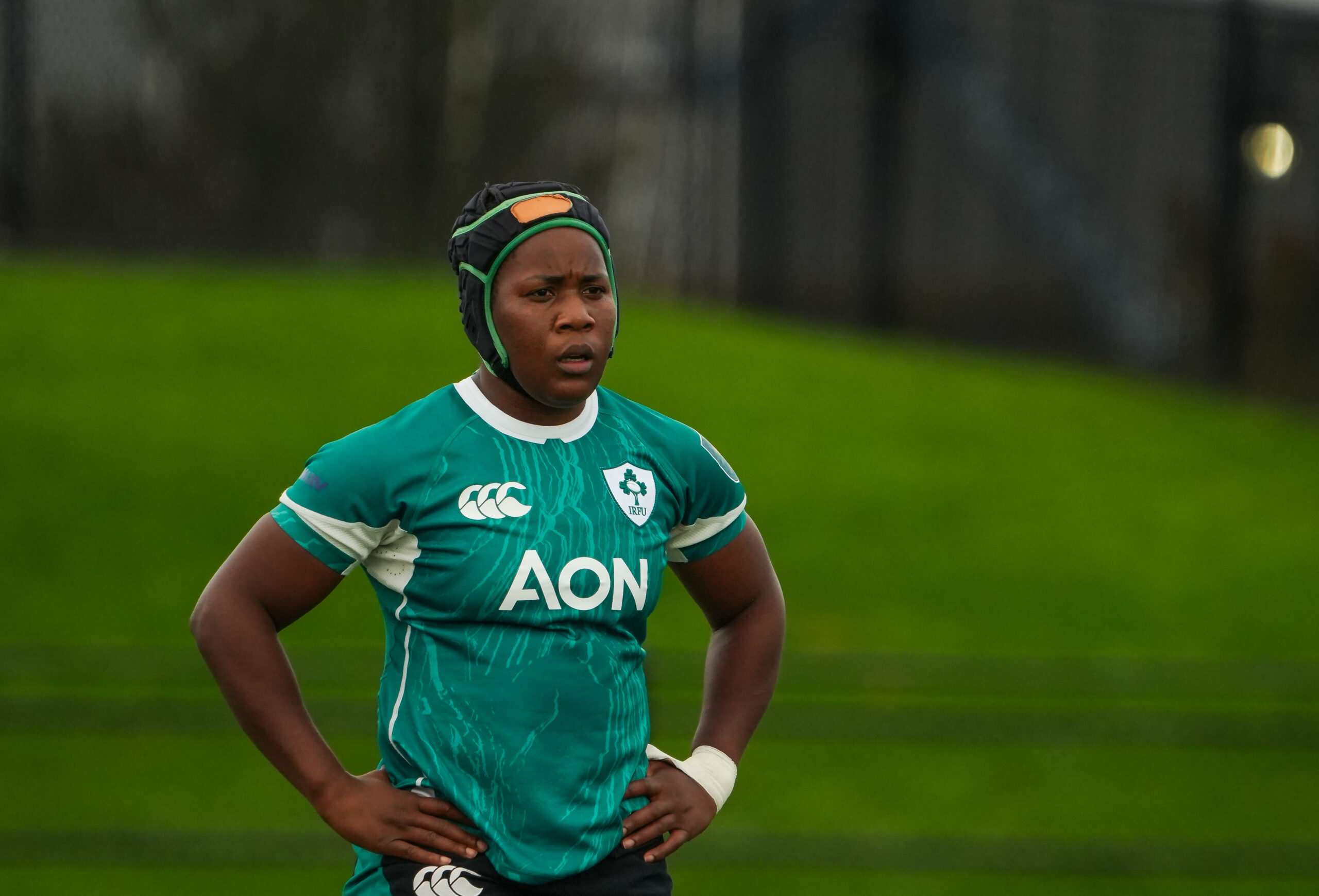 Portrait of an Ireland Women's Rugby player wearing a protective scrum cap on the field.