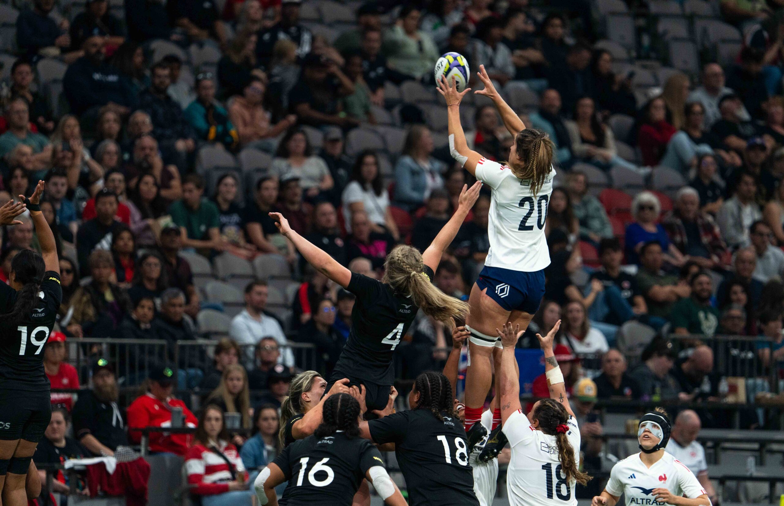 Rugby lineout action with a France player being lifted to catch the ball against New Zealand.