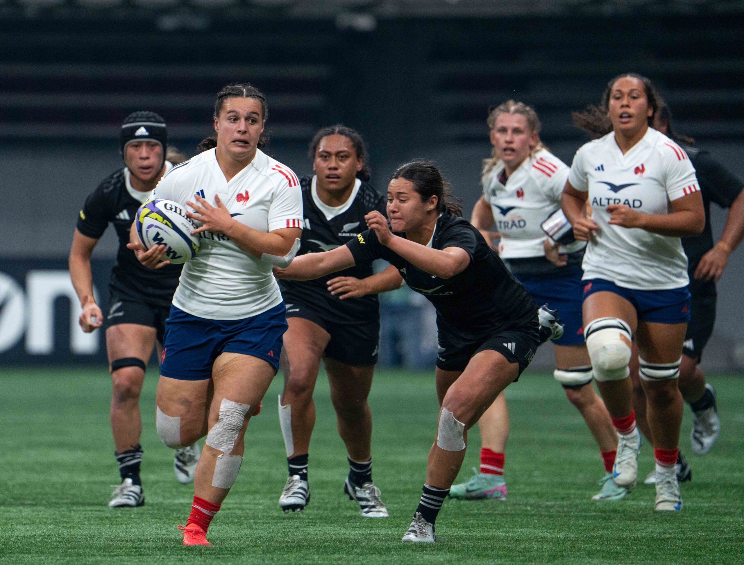 France rugby player sprinting with the ball while New Zealand players chase during an international test.