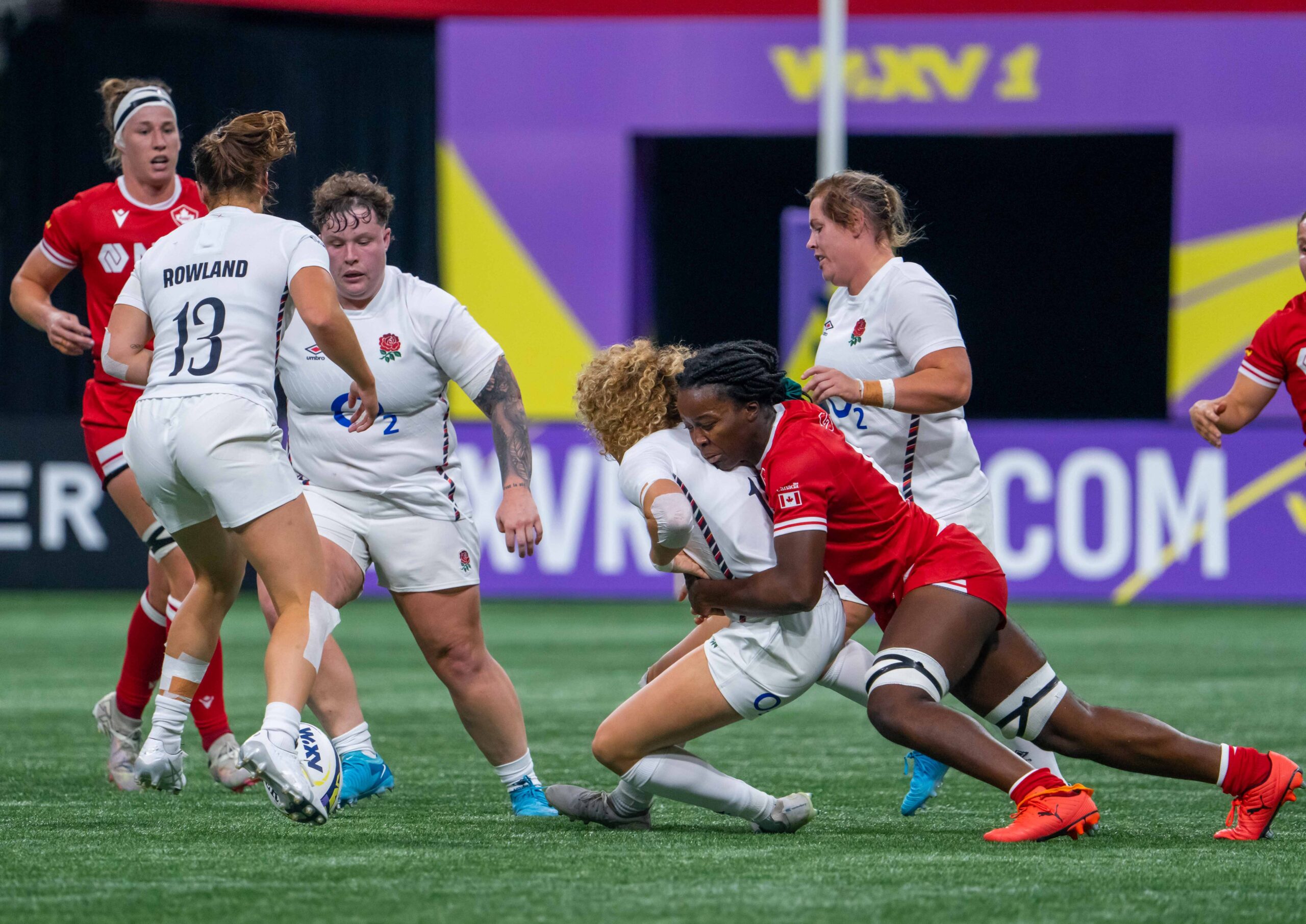 England's Helena Rowland (13) engaged in a physical tackle against Canada Women's Rugby team.
