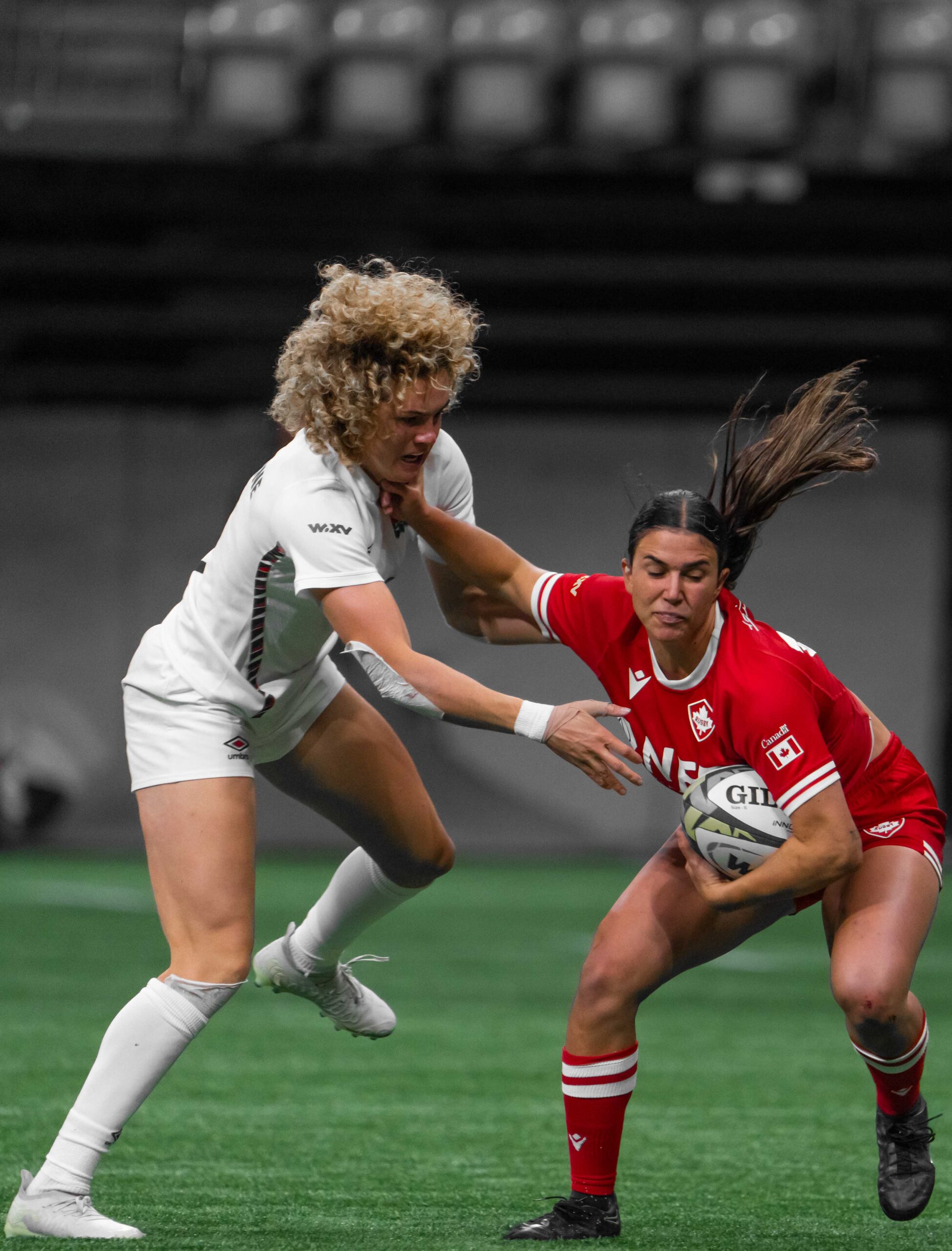 Close-up of Canada rugby player fending off England's defense during a line break in WXV 1.