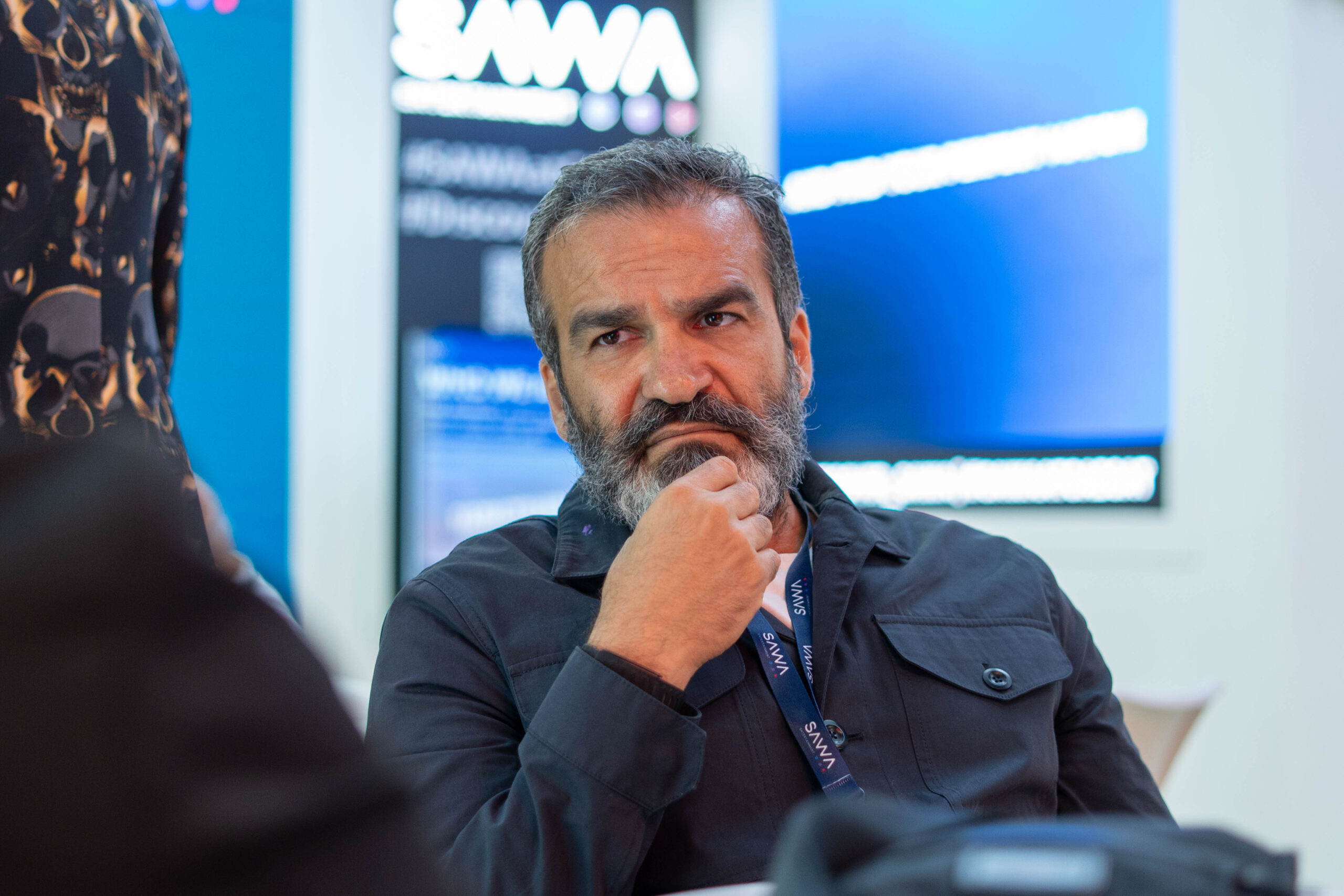 Portrait of a media industry leader thinking at the SAWA exhibition.