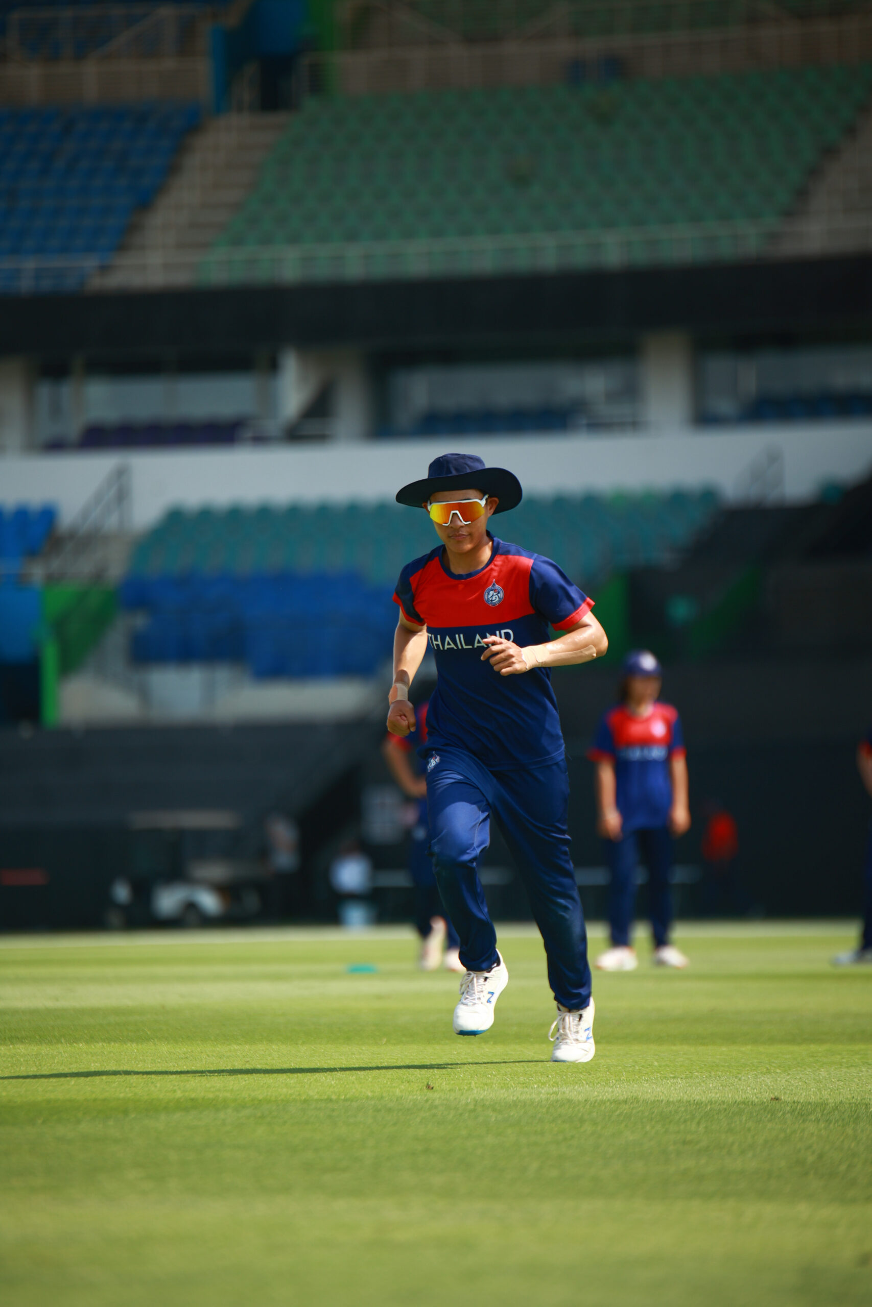 Thailand women's cricket team player running on the field during a professional match in Dubai, United Arab Emirates