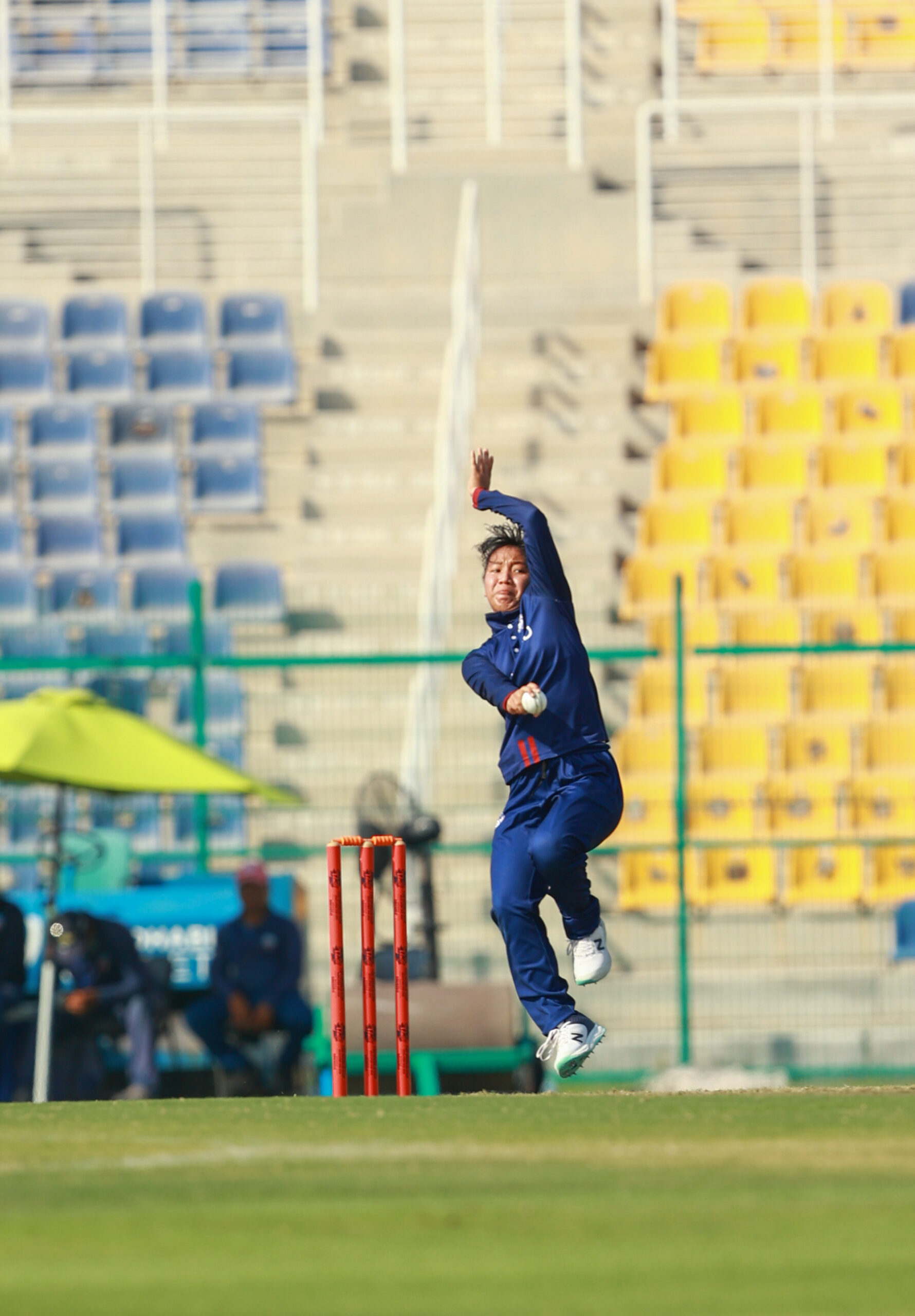 Thailand women's cricket bowler in action at a stadium in Dubai, UAE, during an international match