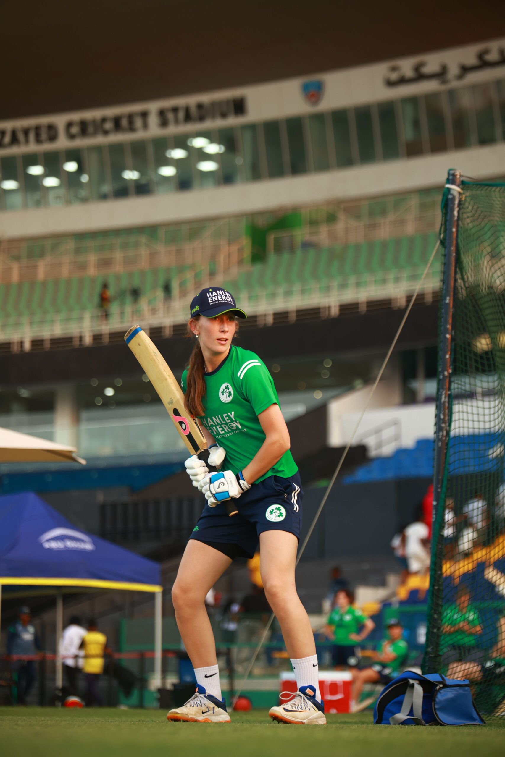 Ireland female batter in a batting stance during a training session at Zayed Cricket Stadium.